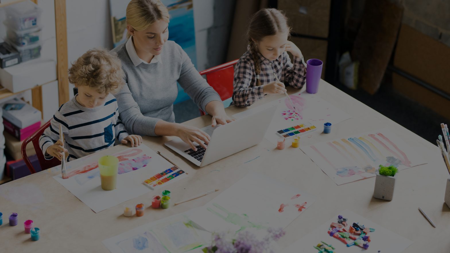 Mother working at home with her two children next to her