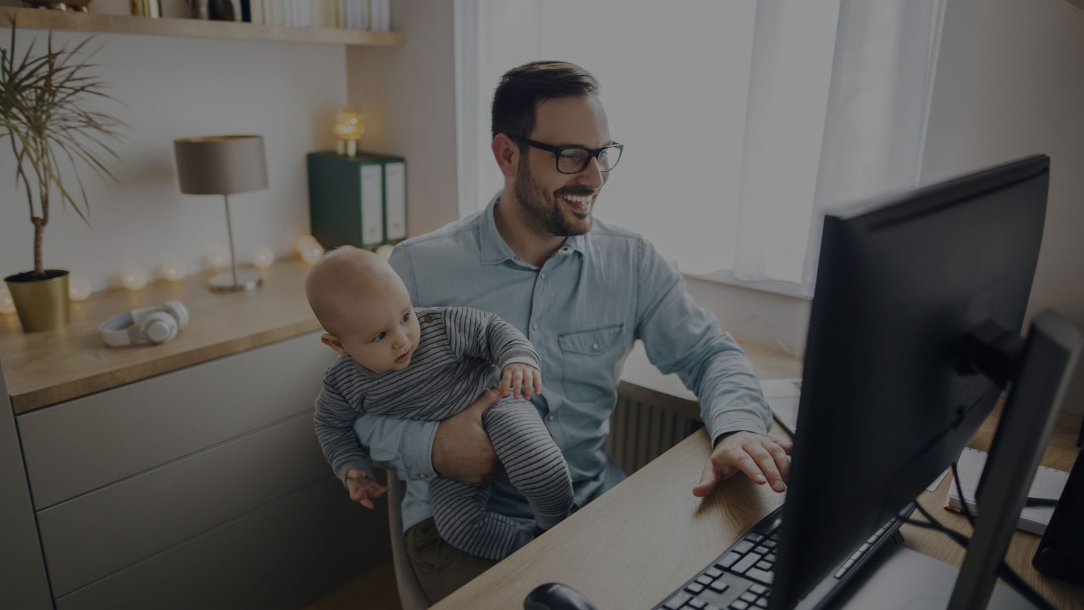 Man working from home while holding his baby